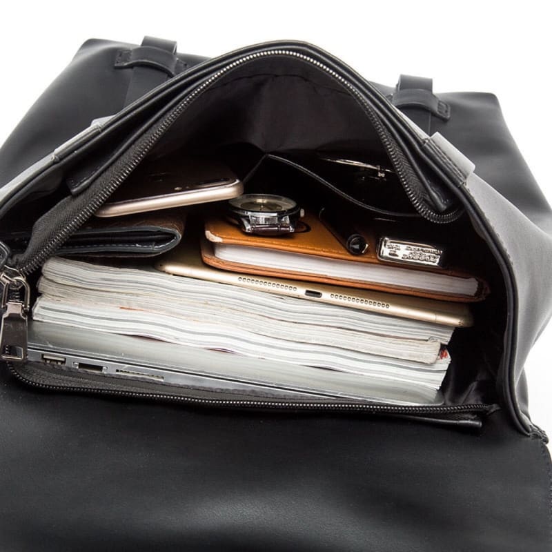 Black leather bag with an open zipper revealing contents inside.