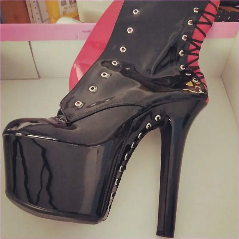 Black patent leather platform stiletto boot with lace-up detail and metal eyelets.