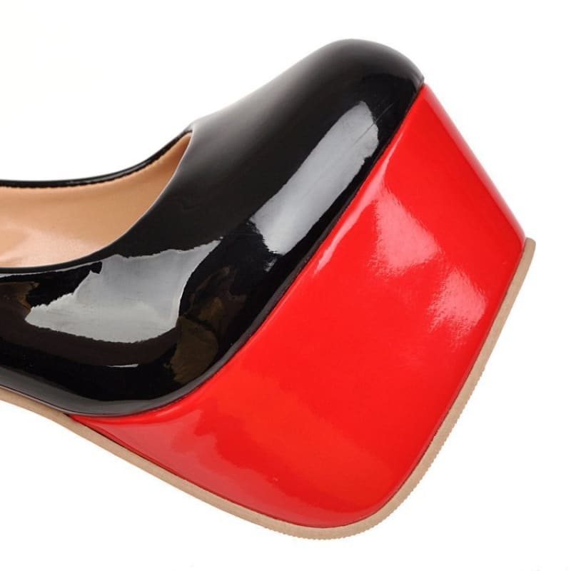 High-heeled shoe with a black upper and red platform sole.