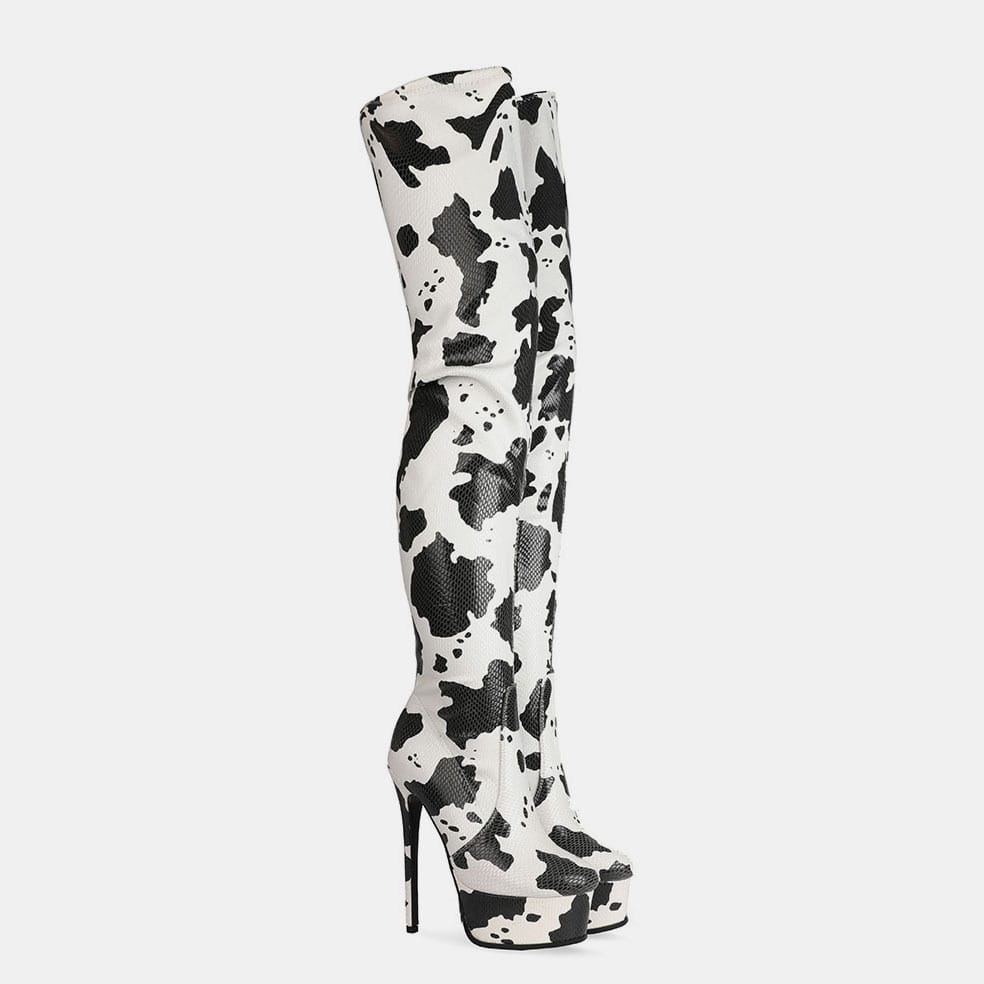 Thigh length platform boots with a trendy black and white cow print design.