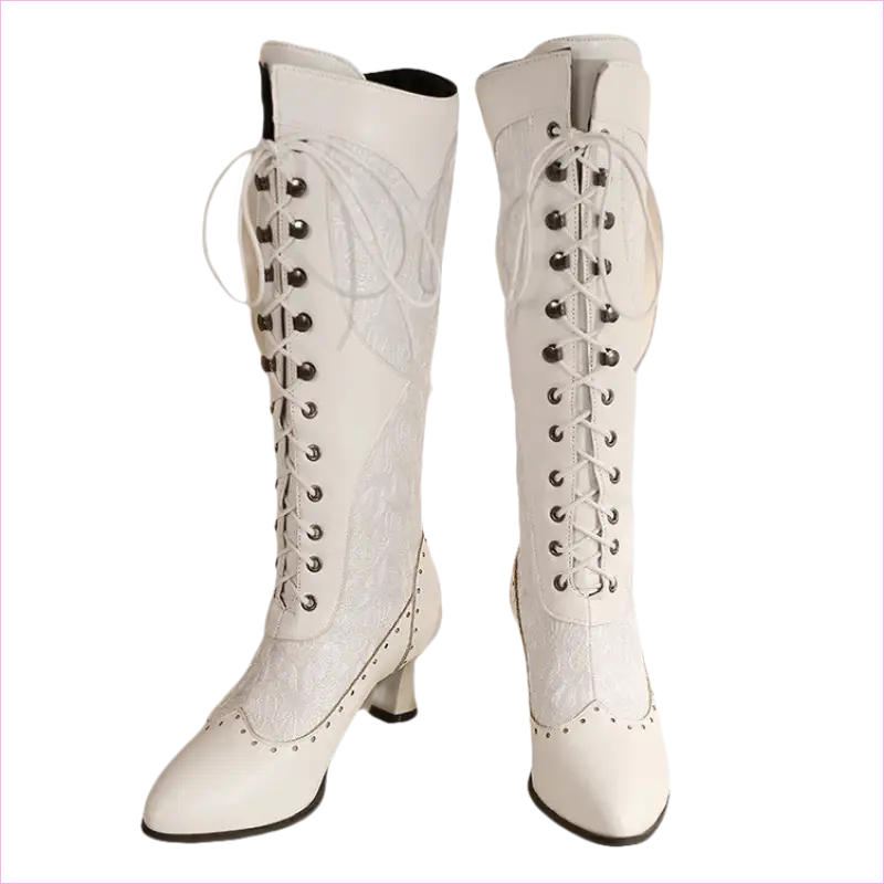 Pair of white knee-high lace-up boots with pointed toes and heels.