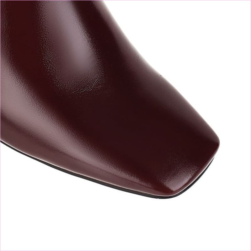 Glossy burgundy leather shoe toe with a square-shaped tip.