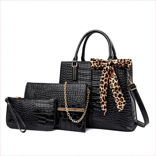 Black crocodile-textured handbag with leopard print scarf accent, accompanied by matching wallet and clutch.