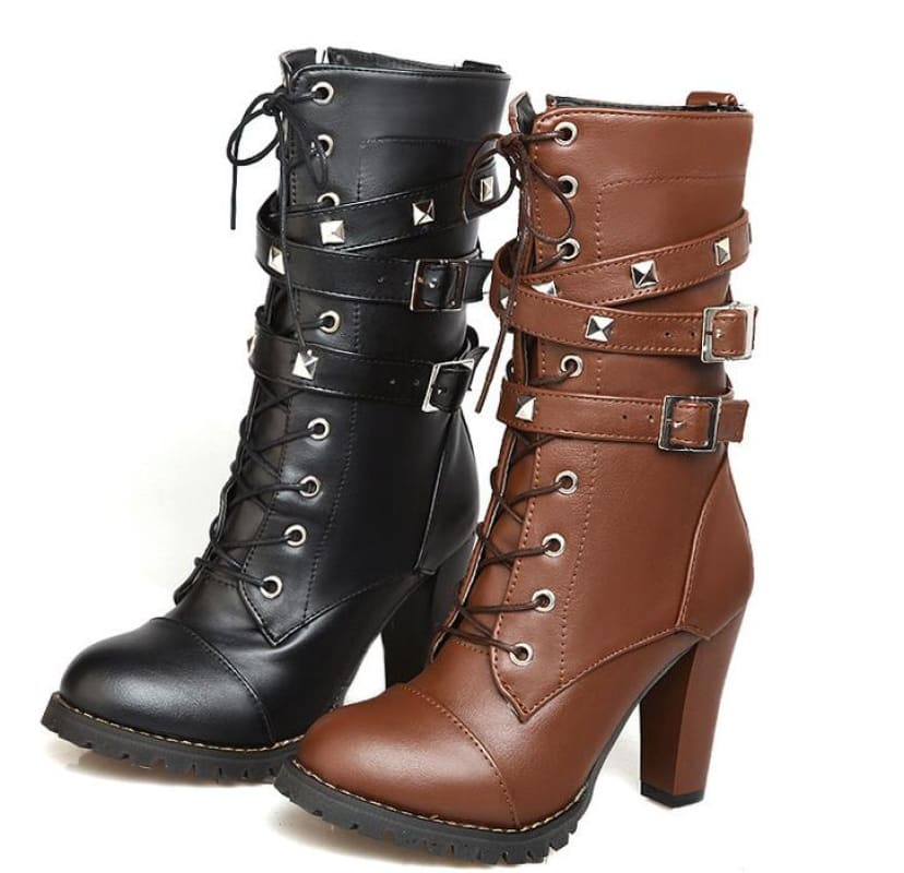 Pair of high-heeled combat-style boots in black and brown leather with laces, buckles, and studs.