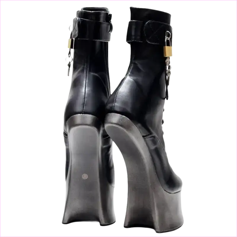 Pair of black leather ankle boots with extremely high wedge heels and gold-toned hardware.
